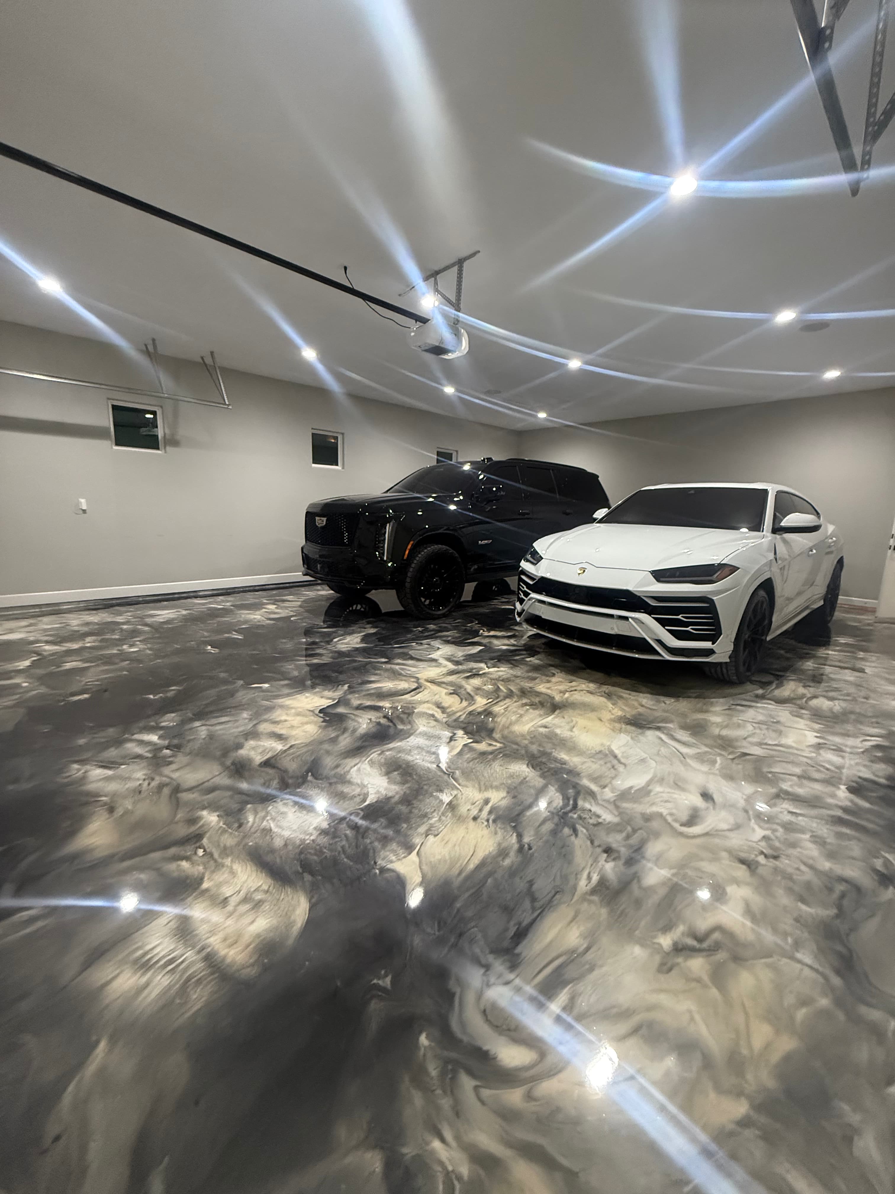 Metallic epoxy garage floor with luxury cars
